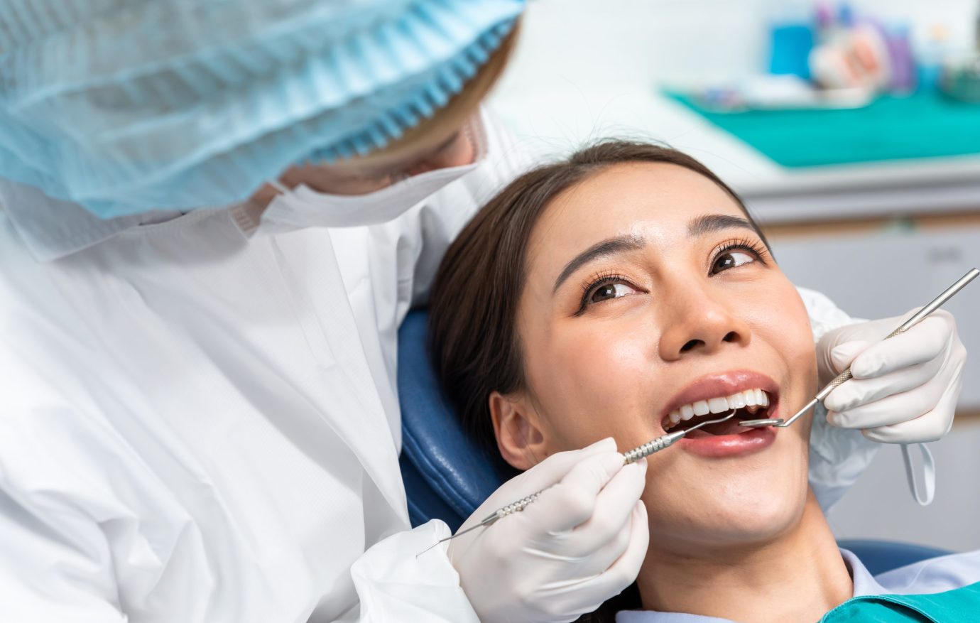 Caucasian dentist examine tooth for young girl at dental health clinic. Attractive woman patient lying on dental chair get dental treatment from doctor during procedure appointment service in hospital